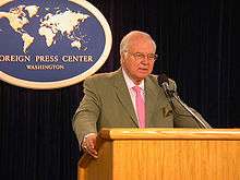 Michael Novak behind a lectern, speaking at the Foreign Press Center in Washington