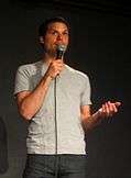 Michael Ian Black holding a microphone at a stand-up comedy performance