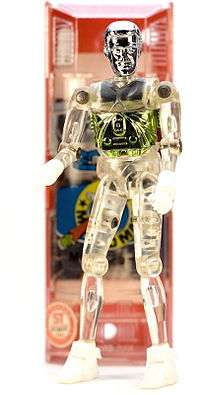 A photo of a vintage Microman M101 (George) 3.75-inch-tall (9.5 cm) action figure with capsule in the background.