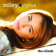 A female teenager lies on her back with her head is tilted over her shoulder to face the viewer. Her straight brunette hair frames her face. The teen wears a plaid shirt, pink lipstick, and has blue green eyes. The words "Miley" and Cyrus", separated by a blue star, are printed in white above her face, and the words "the climb" are printed below her face.