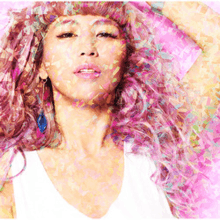 A portrait of singer Minmi, with pink-tinted hair and confetti digitally-superimposed on her.