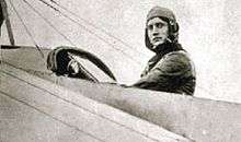 World War I-era pilot, facing the camera from his plane