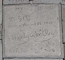 Monty Woolley's concrete tile showing, from the top, the words "My beard" adjoining his beard imprint, the inscription "To Sid [Grauman] Wish you were here", his signature, the date "5-28-43", and his handprints