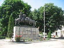 A monument in a park, depicting the killing of a bison by a mounted man