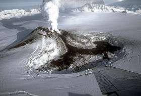 A snow-covered mountain with a plume of steam rising from the top