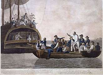 A small open boat, crowded with men, lies astern of a larger vessel. In the small boat a white-clad figure is standing, remonstrating with the figures on the larger boat, some of whom are throwing objects to the open boat.