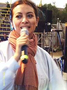 A young woman singing with a microphone.