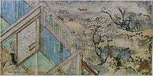 A house, trees with white blossoms and people.