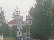 Two road signs adjacent to each other, with the left sign reading to Interstate 78 U.S. Route 22 with a black straight arrow on a white rectangle and the right sign containing a south banner and a black square with a white circle with the number 31.