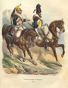 Color print of two cavalrymen riding brown horses. Both dragoons wear white gloves and dark green coats open in front to show a white waistcoat. The trooper on the right has a bearskin hat, gray breeches, and orange-yellow regimental facings; the one on the left sports a brass dragoon helmet, white breeches, and madder red facings.