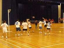 Short and t-shirt wearing players compete against each other.