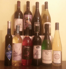 Ten bottles of New Jersey wine stacked in two rows, on a brown table with a yellow background.