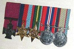 Row of five military medals with ribbons