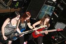 Photograph of three women playing guitar