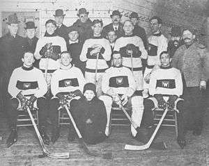 rows of men in hockey uniforms, some men wearing overcoats and hats