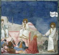 A square fresco. In a shallow stage-like space is shown the empty tomb of Jesus, like a rectangular box of pink marble. Two angels sit on its edge while four Roman soldiers lie sprawled asleep in front of it. To the extreme right, walking out of the picture frame, is Jesus, robed in white and carrying a banner symbolising Victory. He gestures to restrain Mary Magdalene, who kneels at the centre of the picture in a red cloak, and reaches out both hands to touch him.