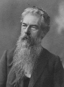 Bust-length black and white portrait of Selfe with long grey beard, looking into the distance.