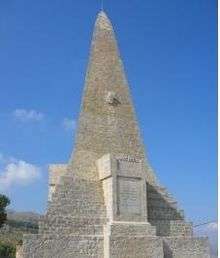 Obelisk constructed from white, dressed, stone, with a wide, stepped base.