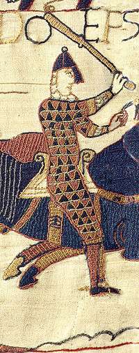 Embroidered image of a walking man in chainmail and helm holding a club over his head