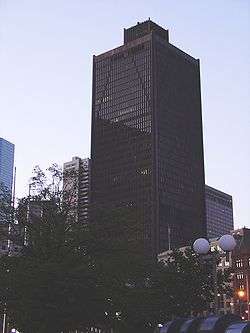 Ground-level view of a 40-story skyscraper with a black, X-braced facade; the building has a major setback near the 35th-floor