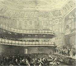 interior of nineteenth century concert hall, with audience in place