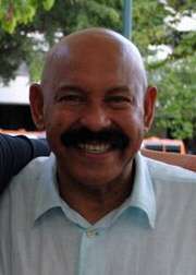 A man with a thick mustache is wearing light blue shirt.