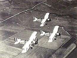 Overhead shot of three military biplanes in flight