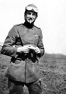 Three-quarters portrait of aviator with raised goggles in military uniform