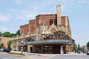 A large elaborate brick and stone building that gets taller in the back. In the front is a modern electronic marquee with the word "Palace" on top. The electronic sign on it says "Congratulations Albany 2009 All-America City".