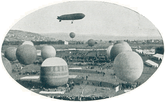 An airship floating behind a number of balloons in the foreground.