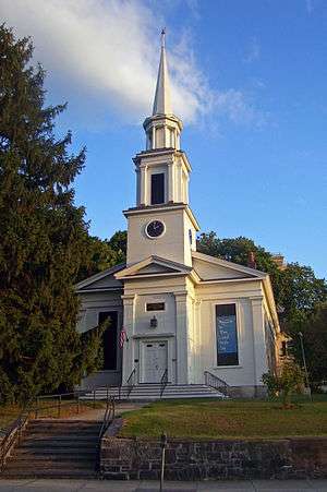Front view of Peekskill Presbyterian Church in evening light, showing retaining wall in front