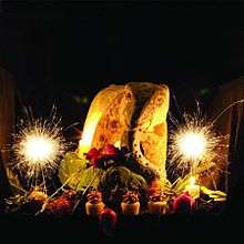 A large plate of food flanked by sparklers