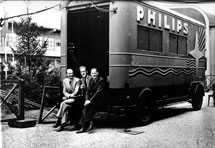 Three men sitting on back of Philips truck