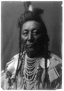 American Indian male in headdress and traditional regalia