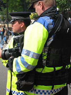Two FIT officers one has a camera and has his back turned the other is observing