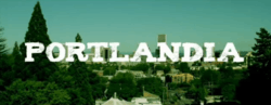 An image of a city skyline in daytime. White text reads "Portlandia".