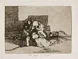 Huddled behind the ruins of a building, two women, one with a child in her arms, lay a third to her permanent rest in the ground. To the rear, another woman lies dead.