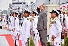 President Mukherjee saluting, surrounded by a naval guard of honour