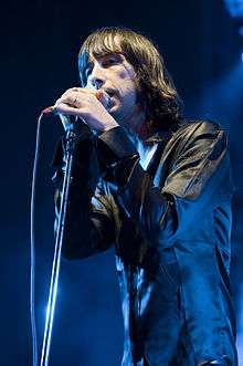 Colour photograph of Bobby Gillespie singing live in 2009.