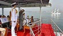 President Mukherjee standing and watching the ships pass