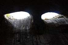 Two eye-like holes in the ceiling of a cave letting light in