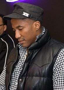 A man wearing a black jacket and baseball cap.