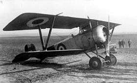 Front three-quarter view of military biplane on airfield