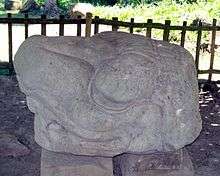 Stone sculpture shaped like the head of an animal looking to the left