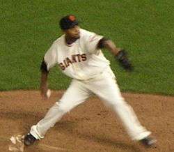 Ramírez in a white uniform that says Giants in black letters preparing to throw a pitch