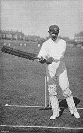 A cricketer about to hit the ball.