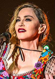 Madonna looking to her right in a colorful blouse
