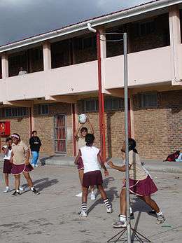 Coloured girls playing netball on an outside court