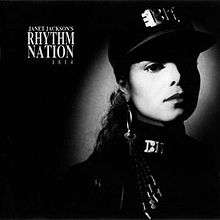 A young woman photographed in black and white wears an all-black, military-styled uniform accented by silver-plated accessories. A spotlight shines on her face. To her left reads the text "Janet Jackson's Rhythm Nation 1814".
