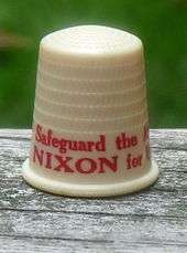 Beige thimble with red lettering, the visible part of which says "Safeguard the A..." and "NIXON for U...